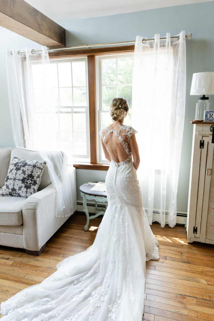 Bride in her wedding dress looking out the window. 